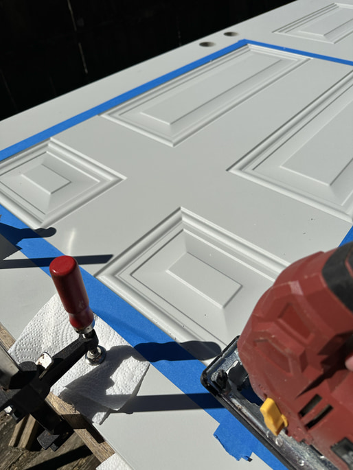 Cutting a hole in the door with a jigsaw.