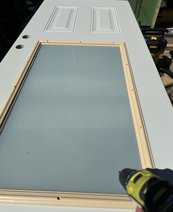 Screwing the door glass into the frame.